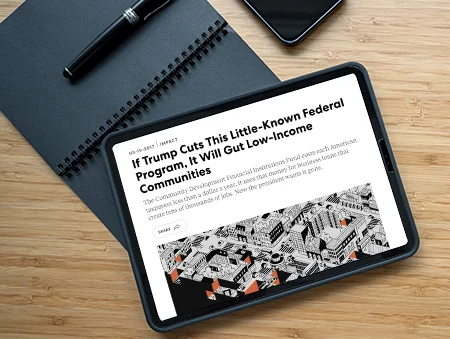 Tablet sitting on spiral notebook near pen and phone