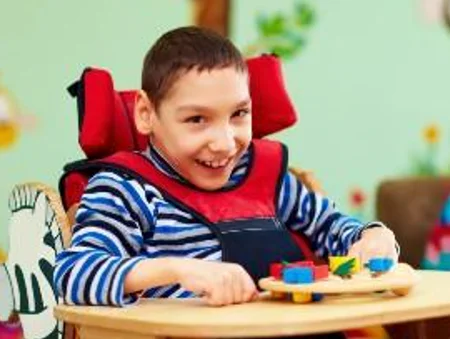 Young boy with disability smiling and playing with a toy